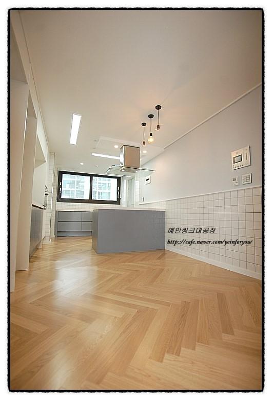 회색 벽면과 나무 바닥이 어우러진 주방