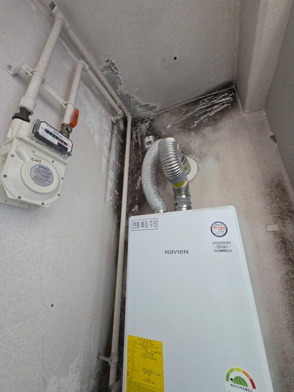 NAVIEN 보일러와 배관이 설치된 흰색 벽면의 모습