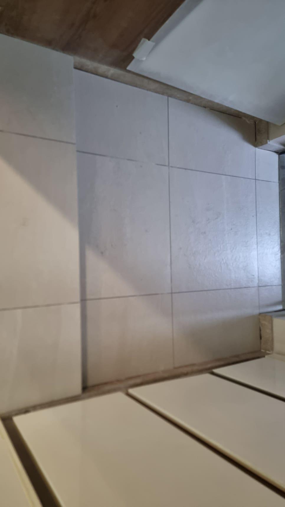 공사 중인 회색 타일 벽면과 화이트 수납장