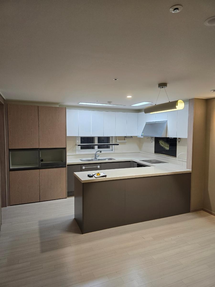 그레이 톤의 가구와 나무 패턴 붙박이장이 조화를 이룬 주방