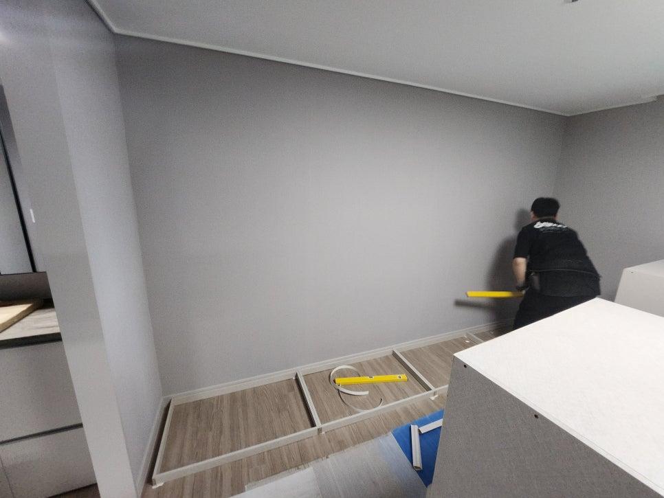 회색 벽면과 흰색 바닥재가 보이는 시공 전 공간