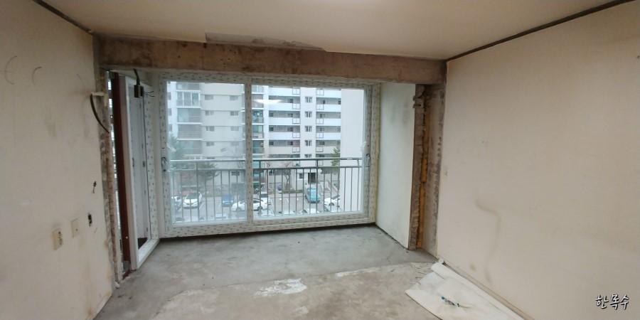 콘크리트 바닥과 흰 벽만 남은 확장 전의 베란다 공간