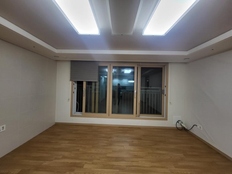 깨끗한 화이트 벽과 우드 바닥이 조화를 이룬 빈 방