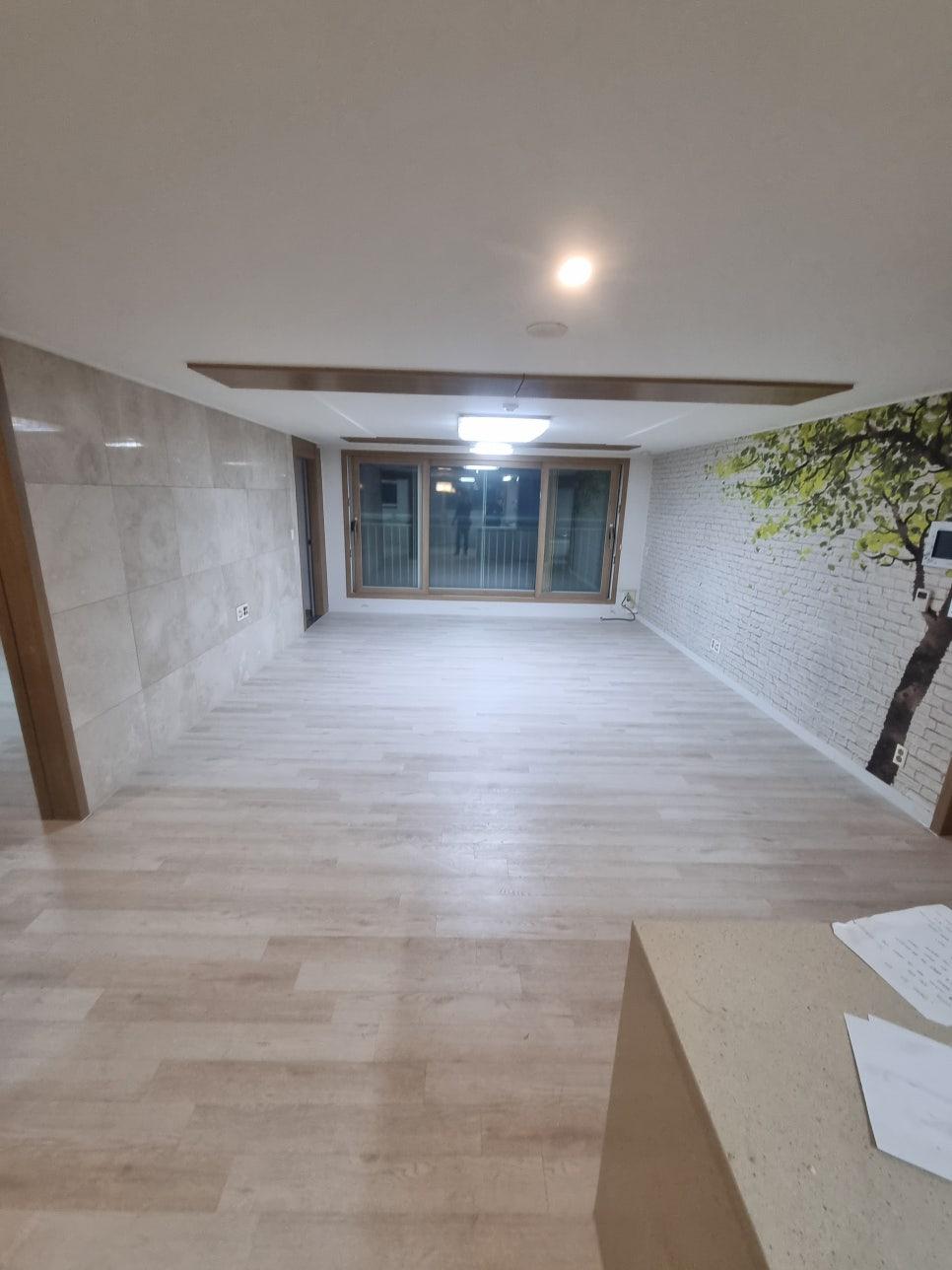 회색 벽돌 패턴과 크림빛 마루가 만난 완성된 거실