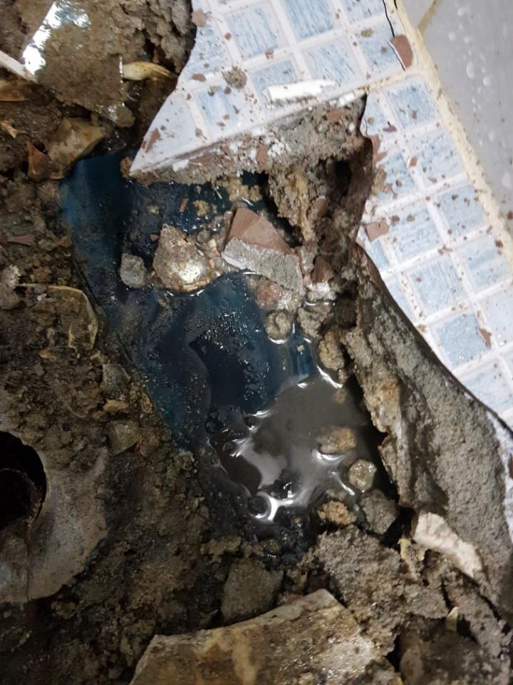 파손된 타일과 물이 고인 바닥 상태