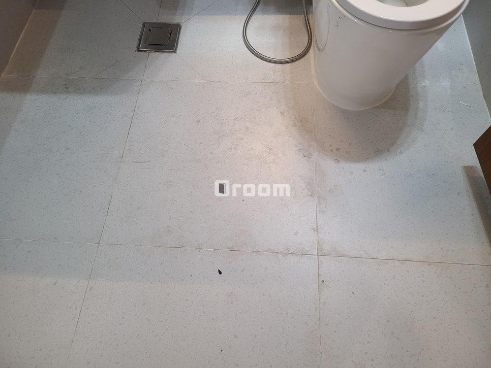 화이트 타일과 변기가 깔끔하게 어우러진 완성된 욕실