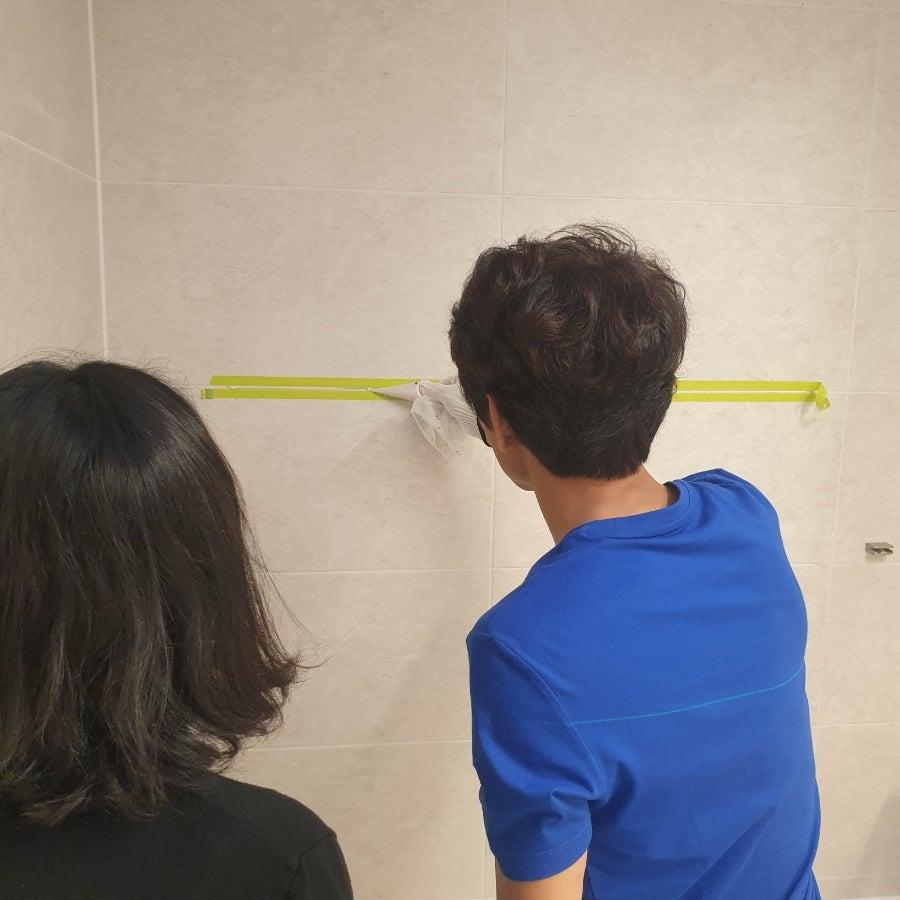 타일 옆면이 보이도록 정교하게 백시멘트를 제거하는 과정